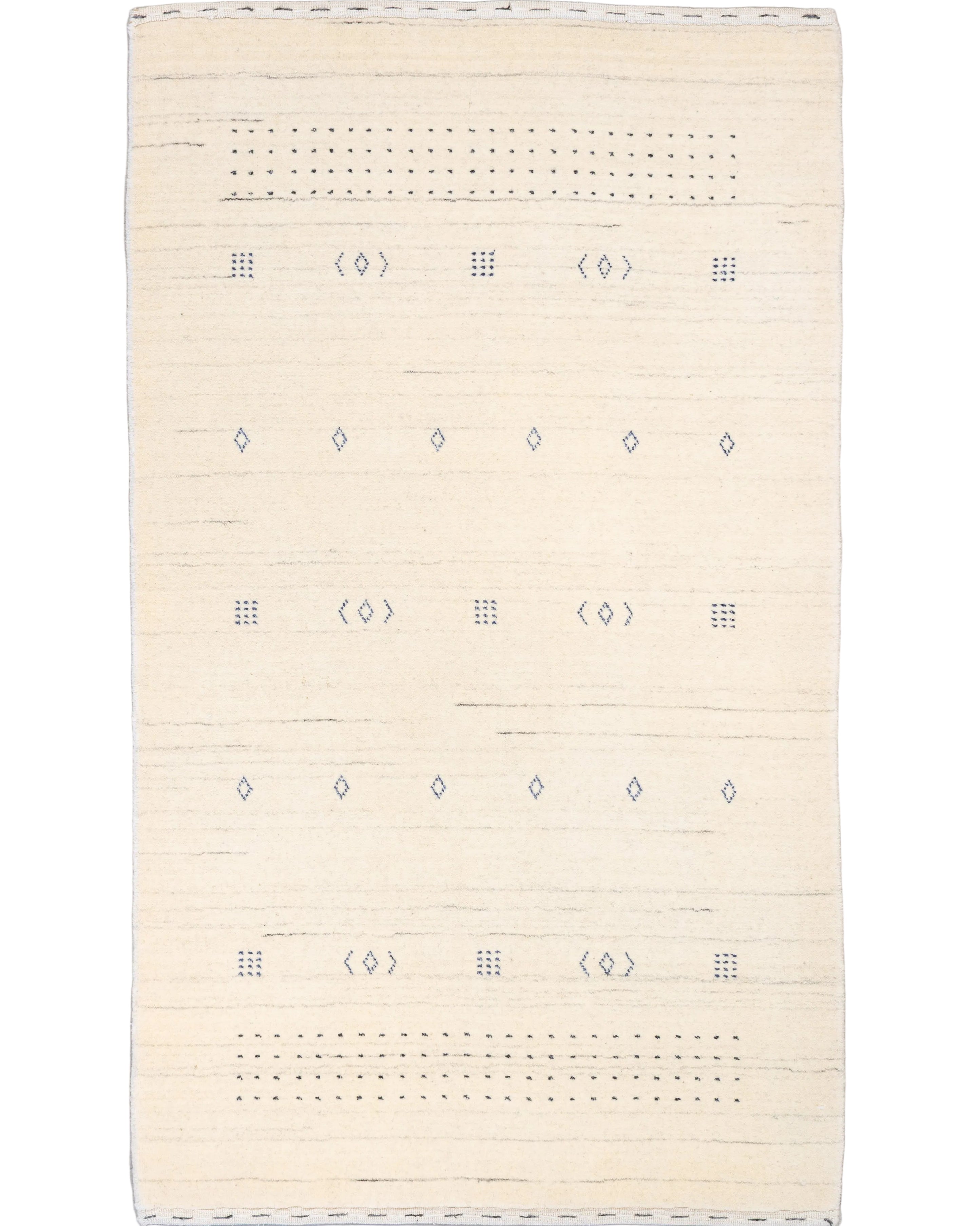 Hand-knotted ivory wool Gabbeh rug with scattered indigo diamond and dot motifs on an open cream field, 3'1" x 5', made in India.