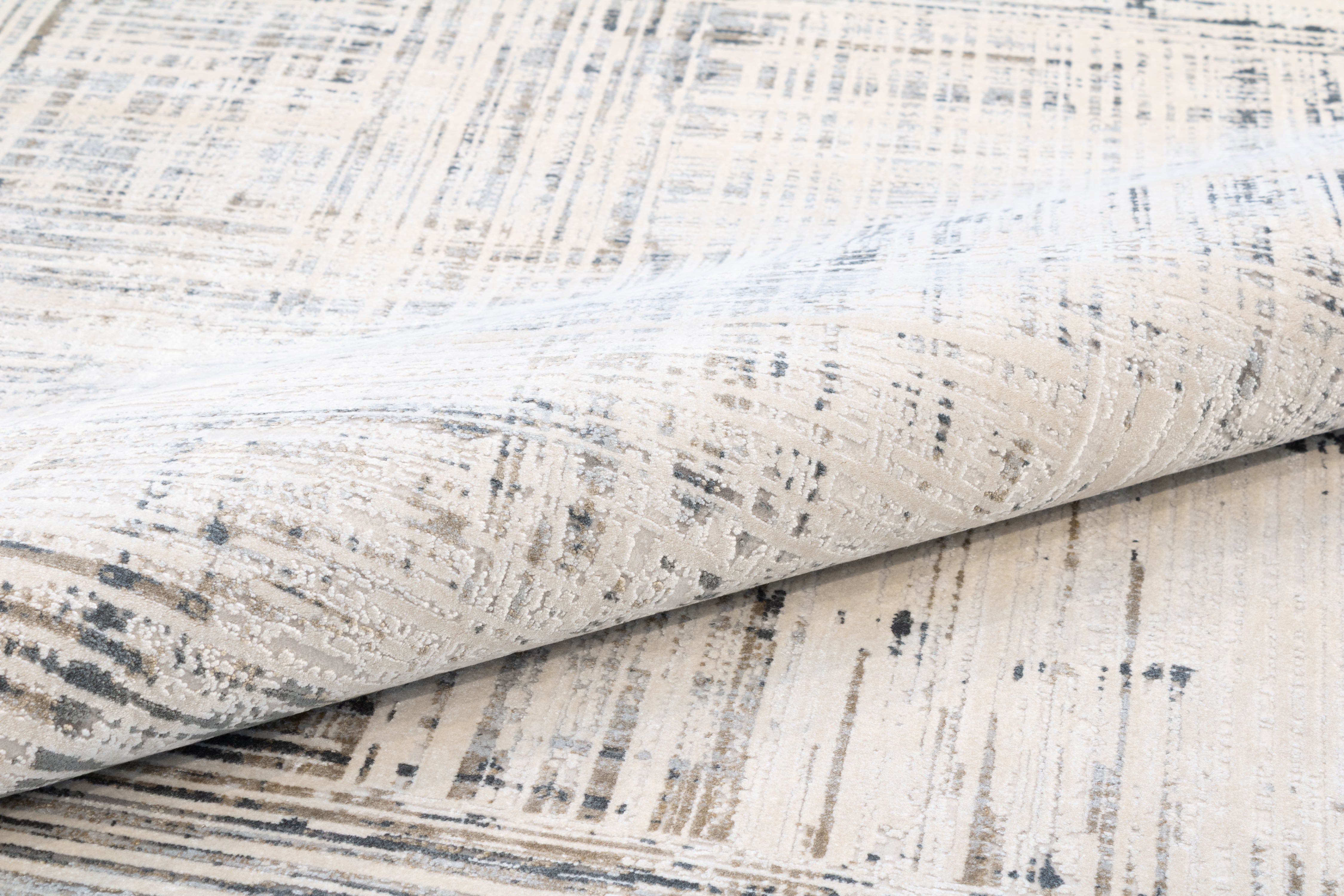 Hampton bamboo silk rug rolled and viewed from above at an angle, highlighting the dimensional crosshatch texture, subtle sheen, and tonal variation across the ivory, taupe, and slate colorway