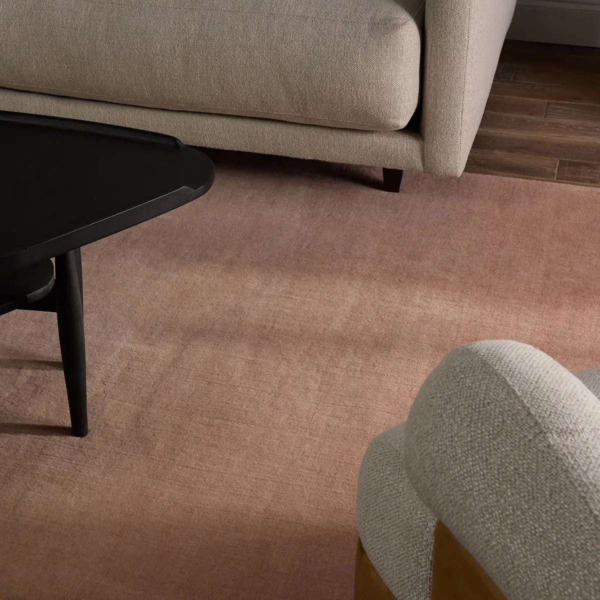 Blush handwoven wool rug with a soft ombré gradient fading to ivory, shown in a living room setting.