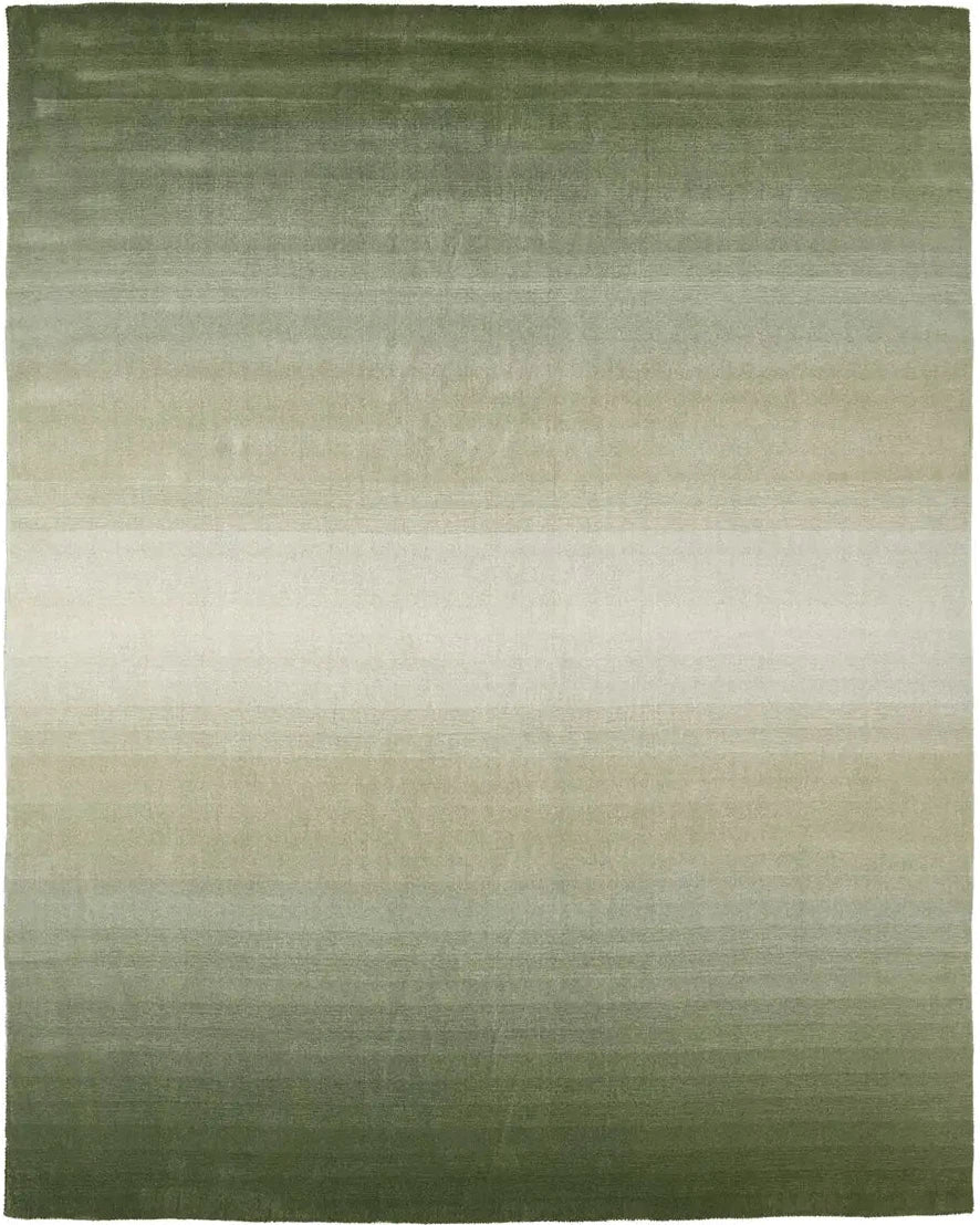 Moss green handwoven wool rug with a soft ombré gradient fading to sage, shown beneath a console table.